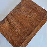 Brown textured leather clutch bag on a light gray background