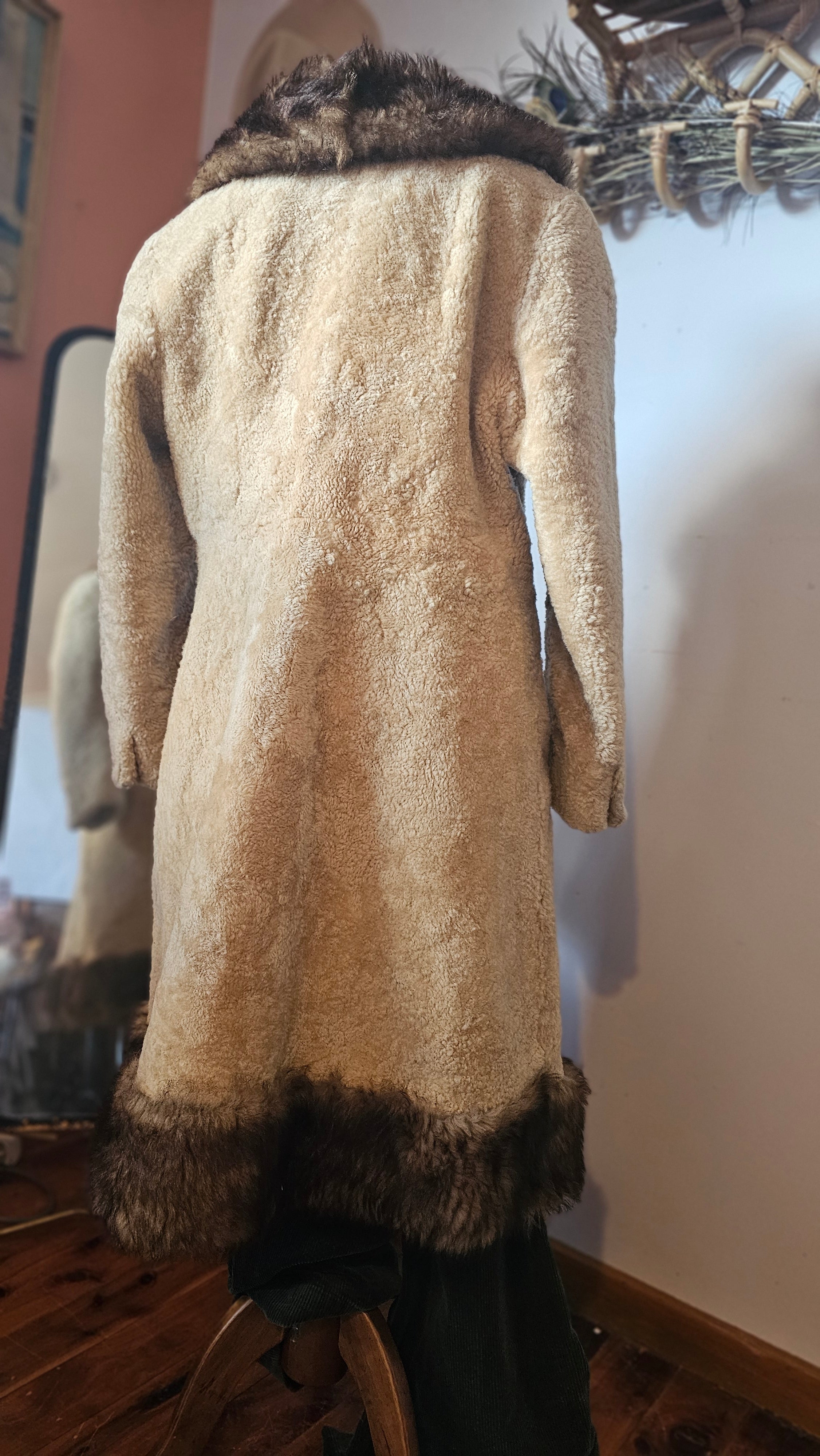 Brown coat with fur trim on a mannequin against a neutral background