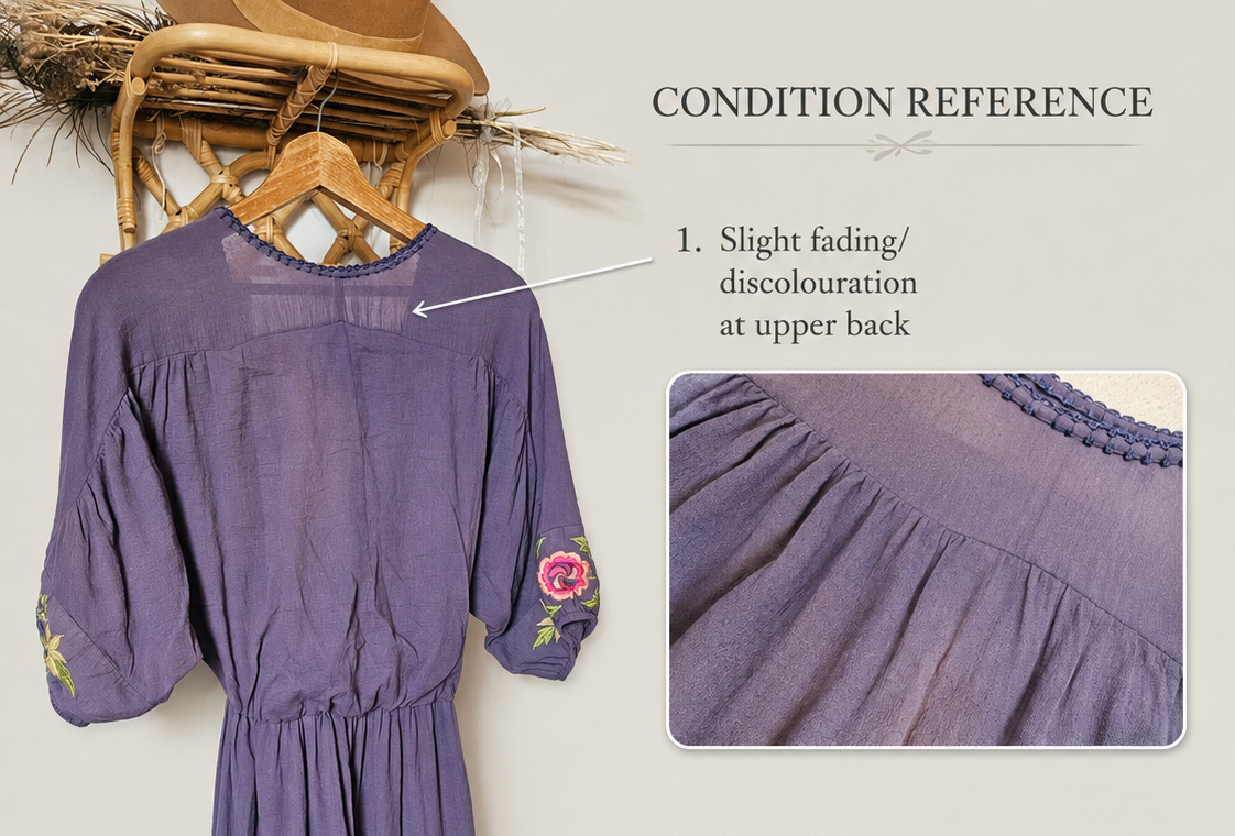 A lavender-purple midi dress with pink floral embroidery on the sleeves and hem, shown hanging on a wooden hanger against a light beige background. The image includes a 'Condition Reference' section with two inset close-ups highlighting fading on the upper back and front skirt, accompanied by explanatory text.