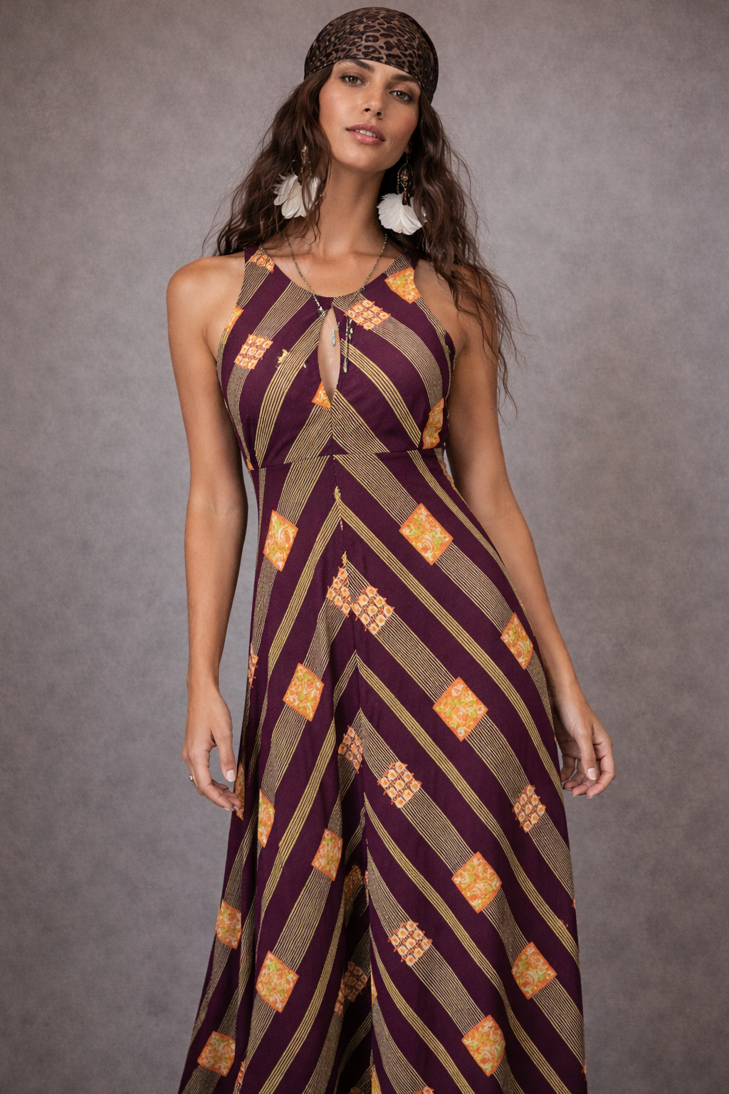 Woman wearing a patterned jumpsuit against a gray background