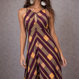 Woman wearing a patterned jumpsuit against a gray background