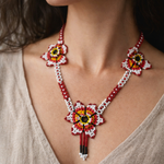 Close-up of a woman wearing a colorful beaded necklace with a neutral background