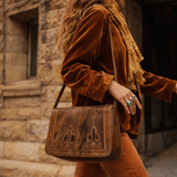 Woman in brown outfit with a textured bag walking on a street.