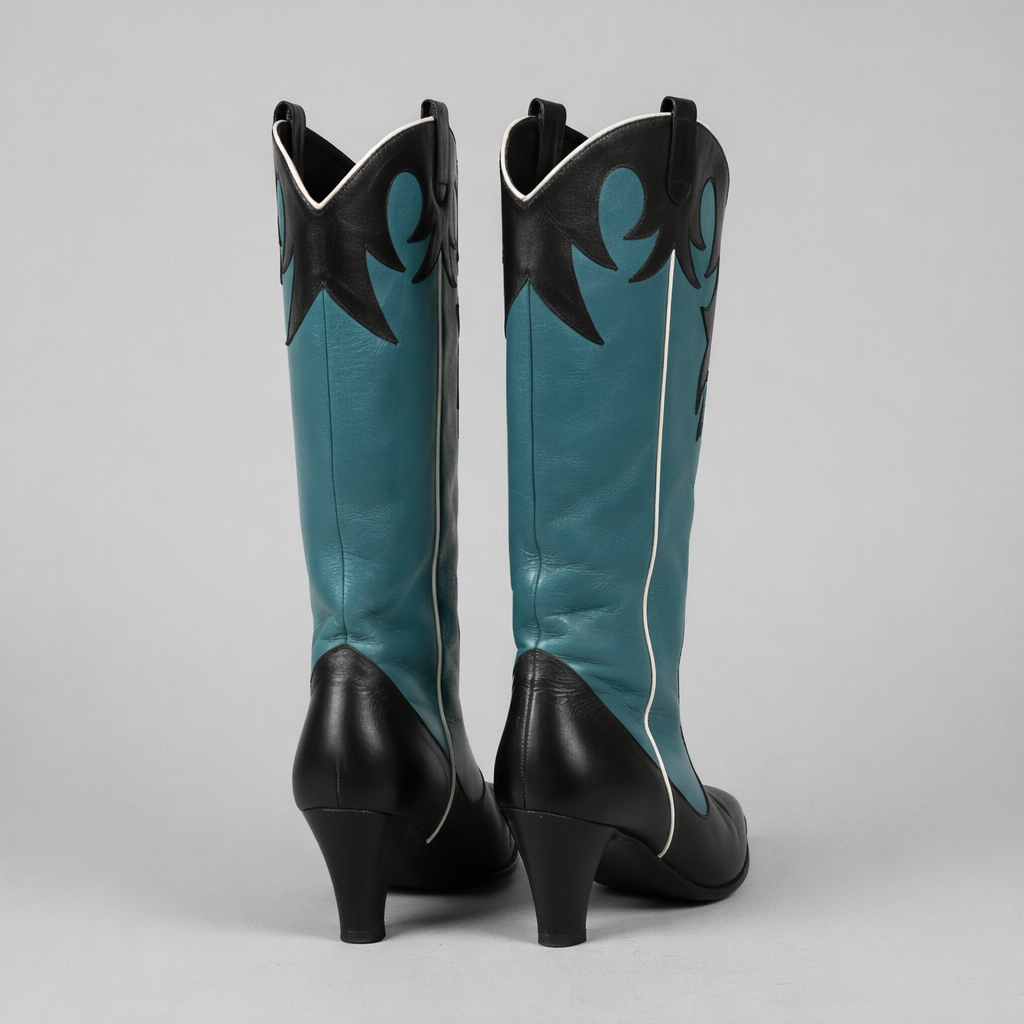 Pair of teal and black cowboy boots on a gray background