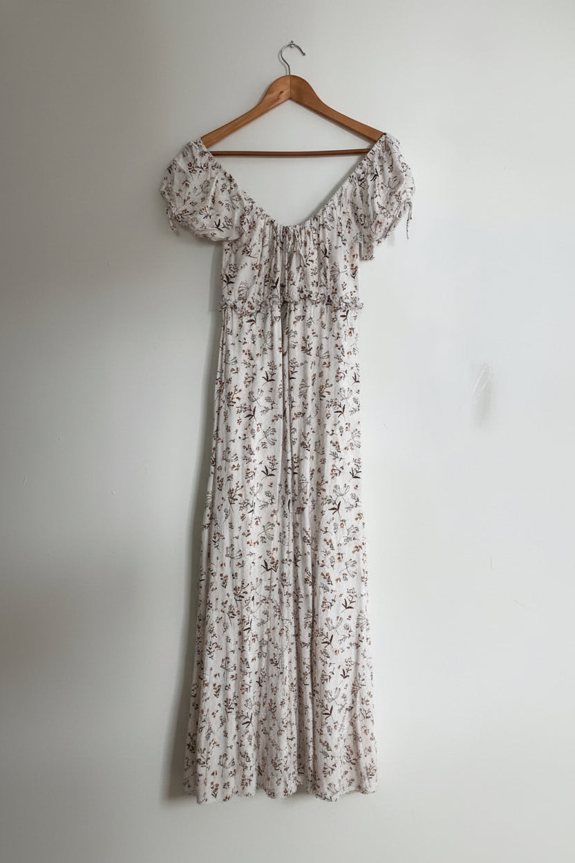 Floral dress on a wooden hanger against a white wall