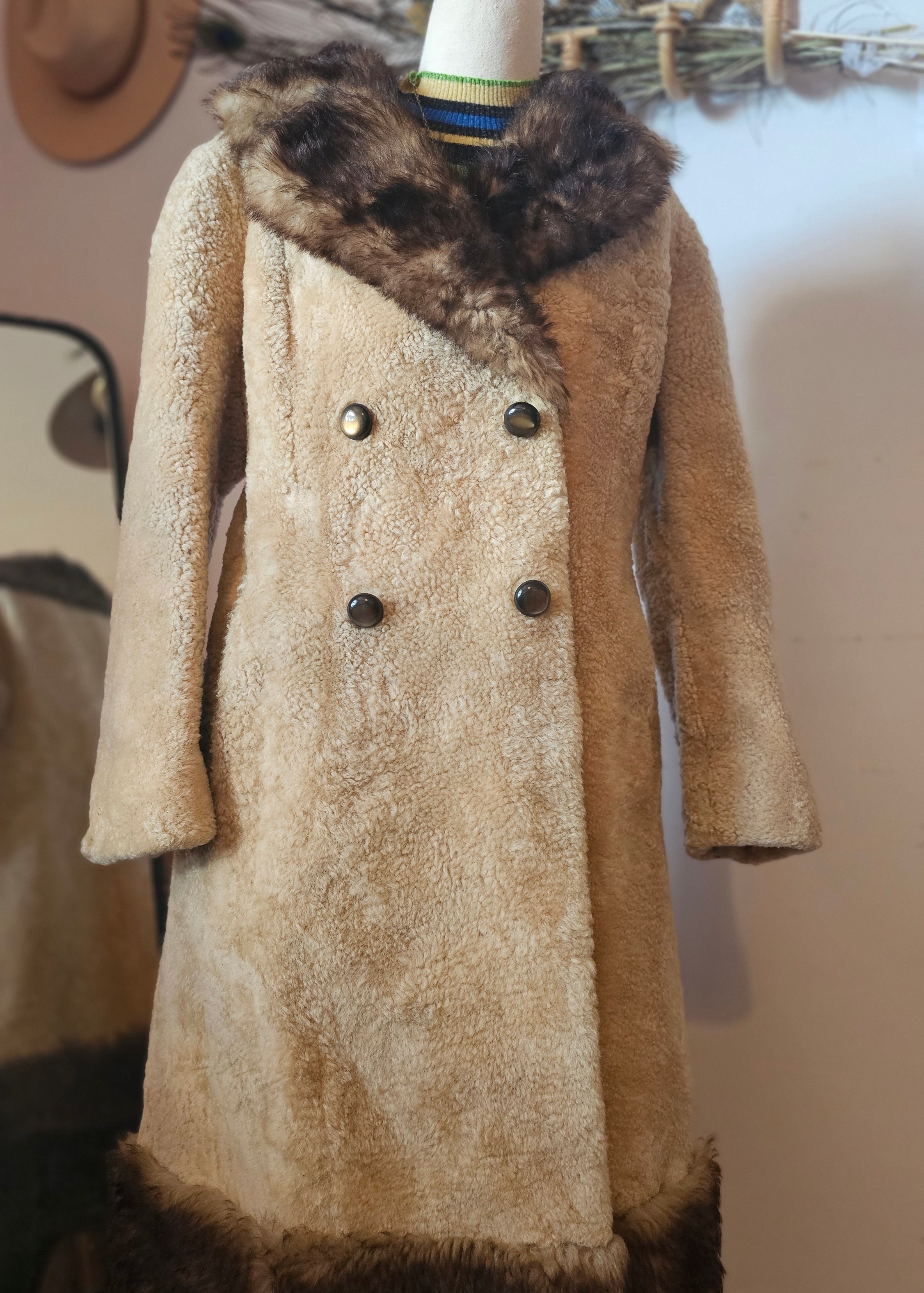 Brown fur-trimmed coat on a mannequin against a neutral background