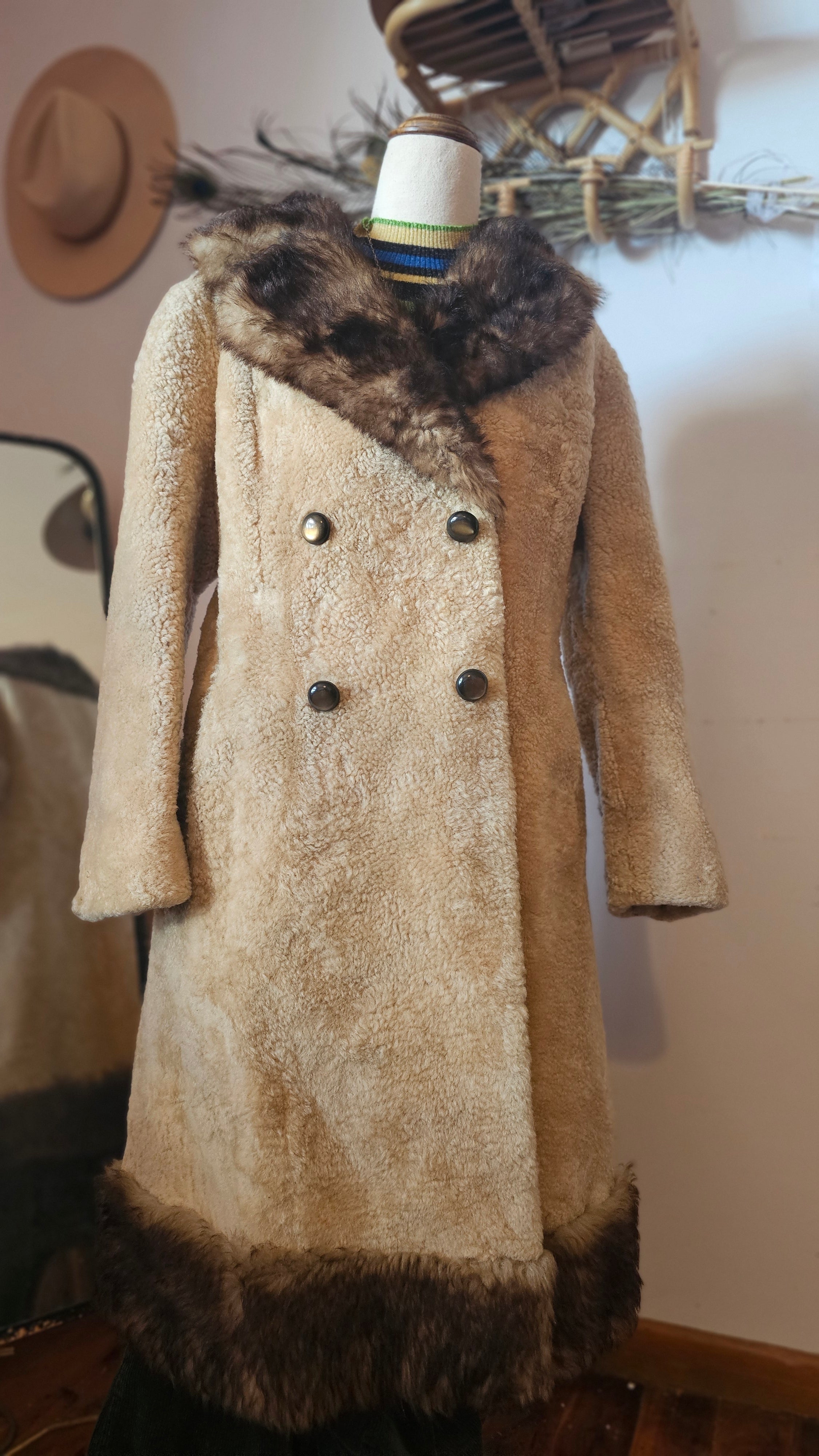 Brown fur-trimmed coat on a mannequin against a neutral background