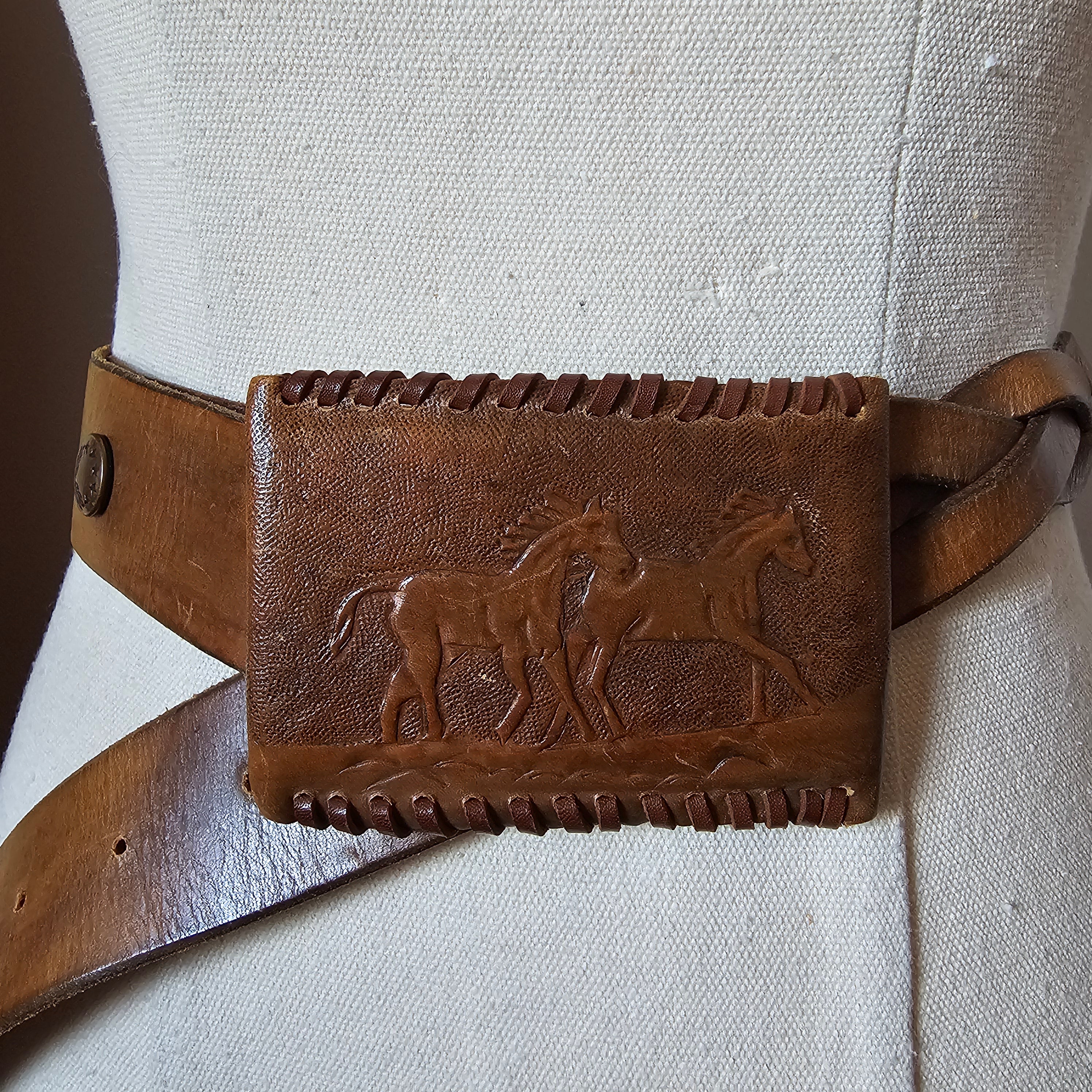 Brown leather belt with embossed design on a light gray background