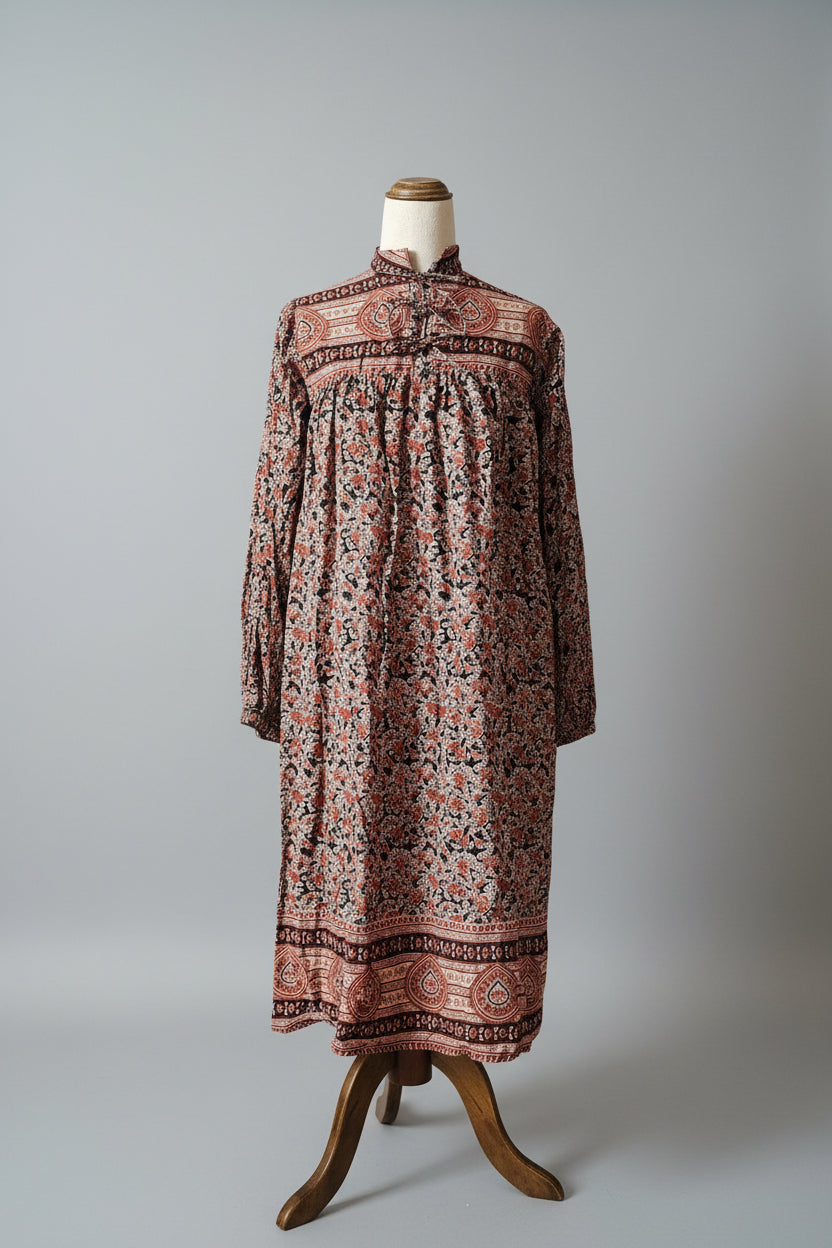 Long patterned dress on a mannequin against a gray background