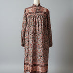 Long patterned dress on a mannequin against a gray background