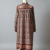 Long patterned dress on a mannequin against a gray background
