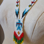 Close-up of a beaded necklace with colorful patterns on a beige fabric background