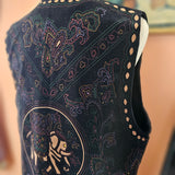 Close-up of a dark blue embroidered shoe with intricate patterns on a blurred background