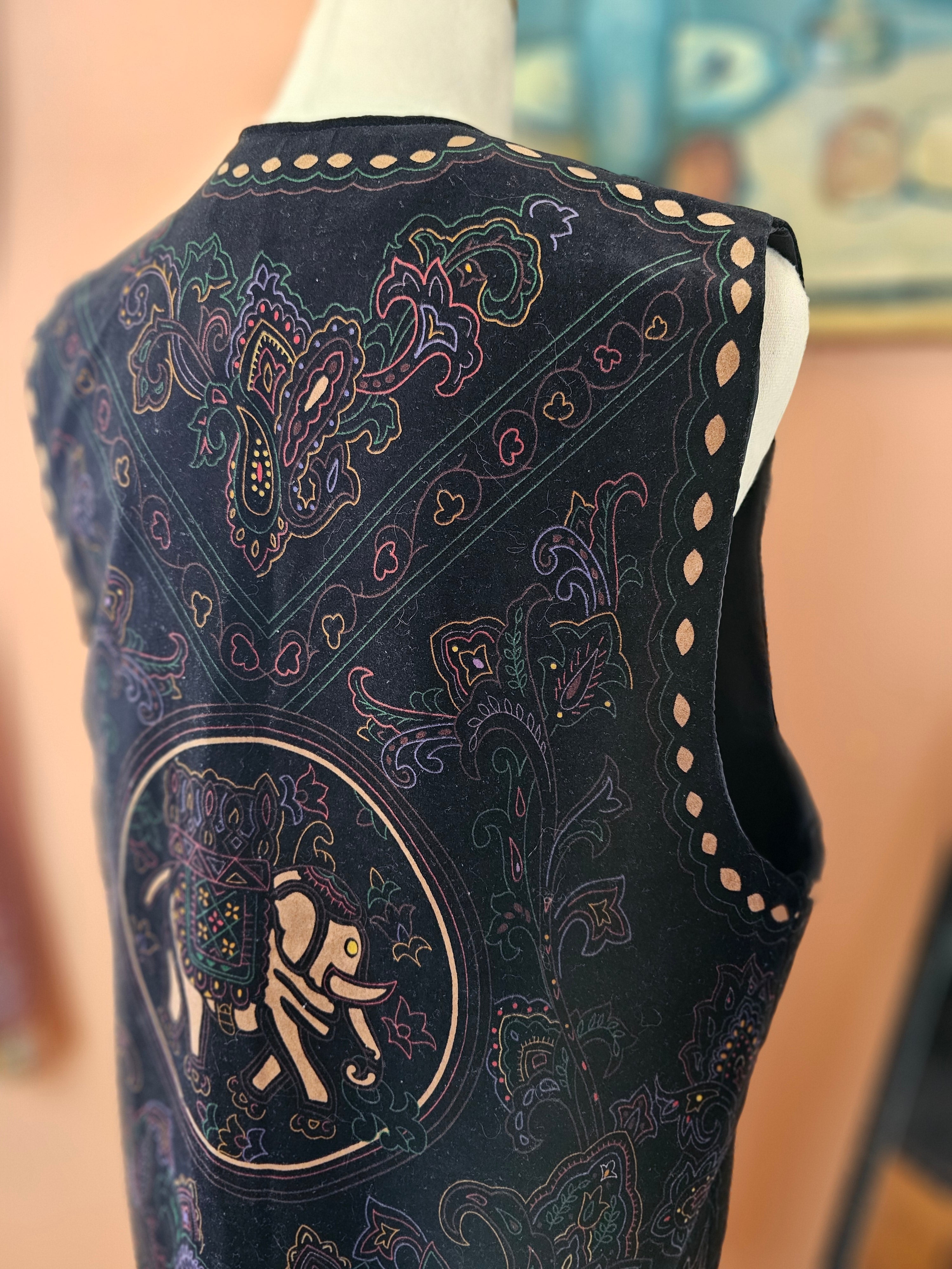 Close-up of a dark blue embroidered shoe with intricate patterns on a blurred background