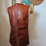 Brown leather bag on a mannequin against a neutral background