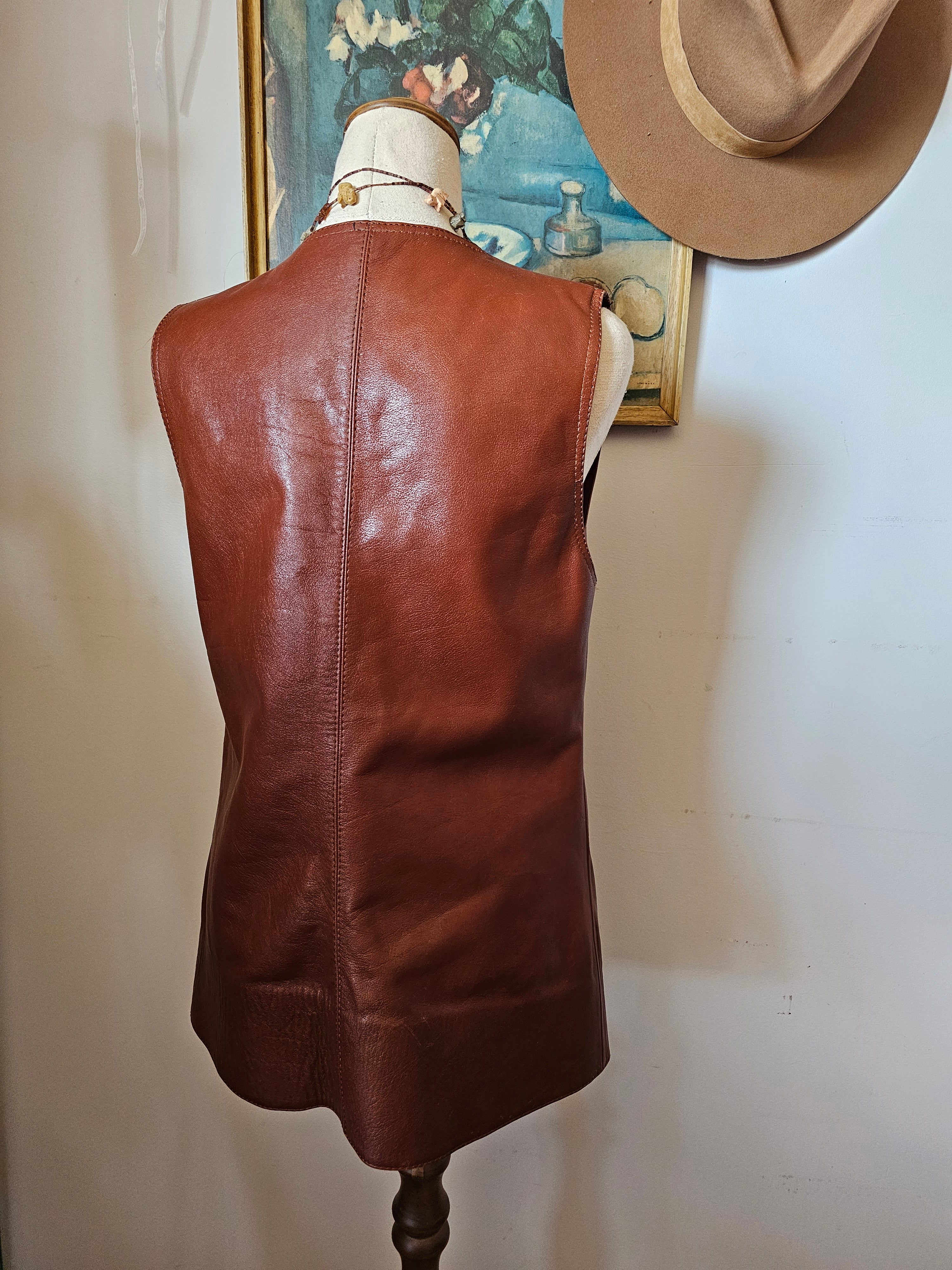 Brown leather bag on a mannequin against a neutral background