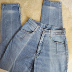 Folded pair of blue jeans on a beige surface