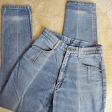 Folded pair of blue jeans on a beige surface