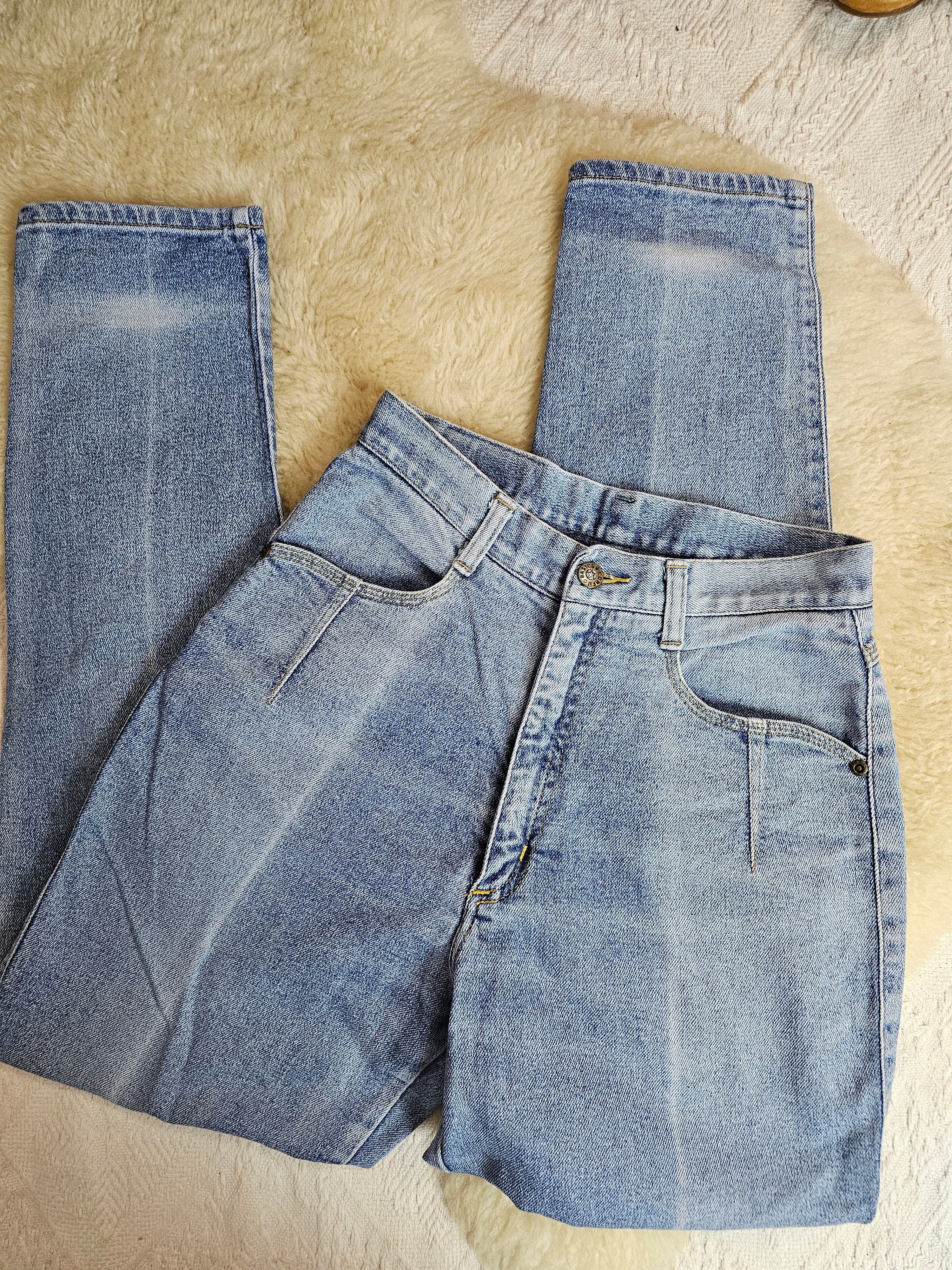Folded pair of blue jeans on a beige surface