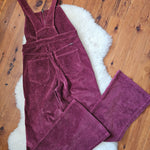 Purple corduroy pants on a wooden floor with a white rug underneath