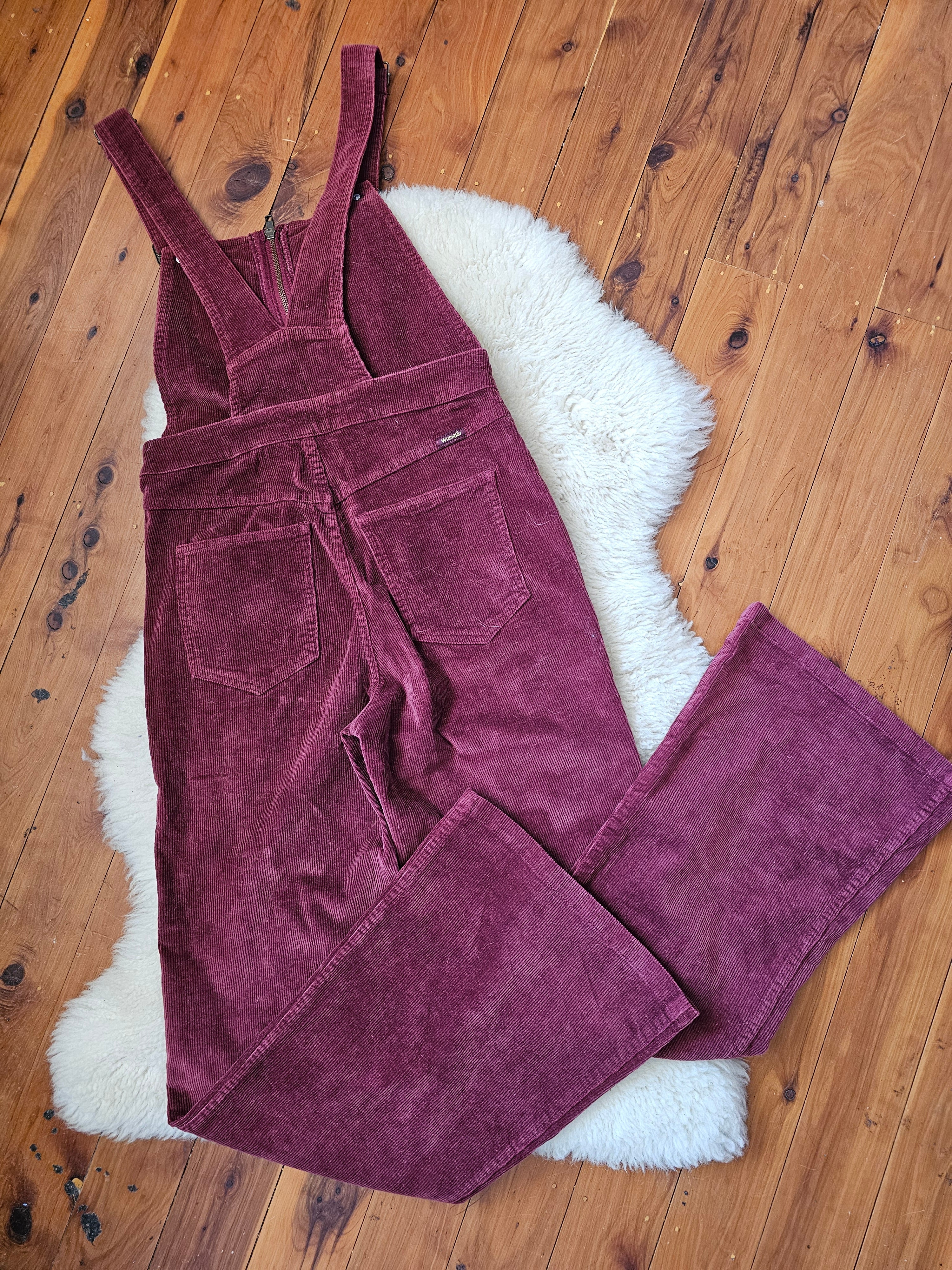 Purple corduroy pants on a wooden floor with a white rug underneath