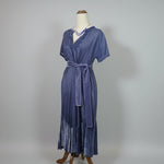 Purple dress on a mannequin against a plain background