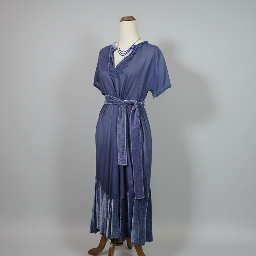 Purple dress on a mannequin against a plain background