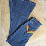 Folded blue jeans on a textured beige surface