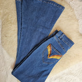 Folded blue jeans on a textured beige surface