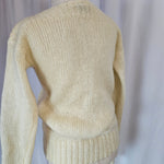 Beige sweater on a mannequin against a neutral background