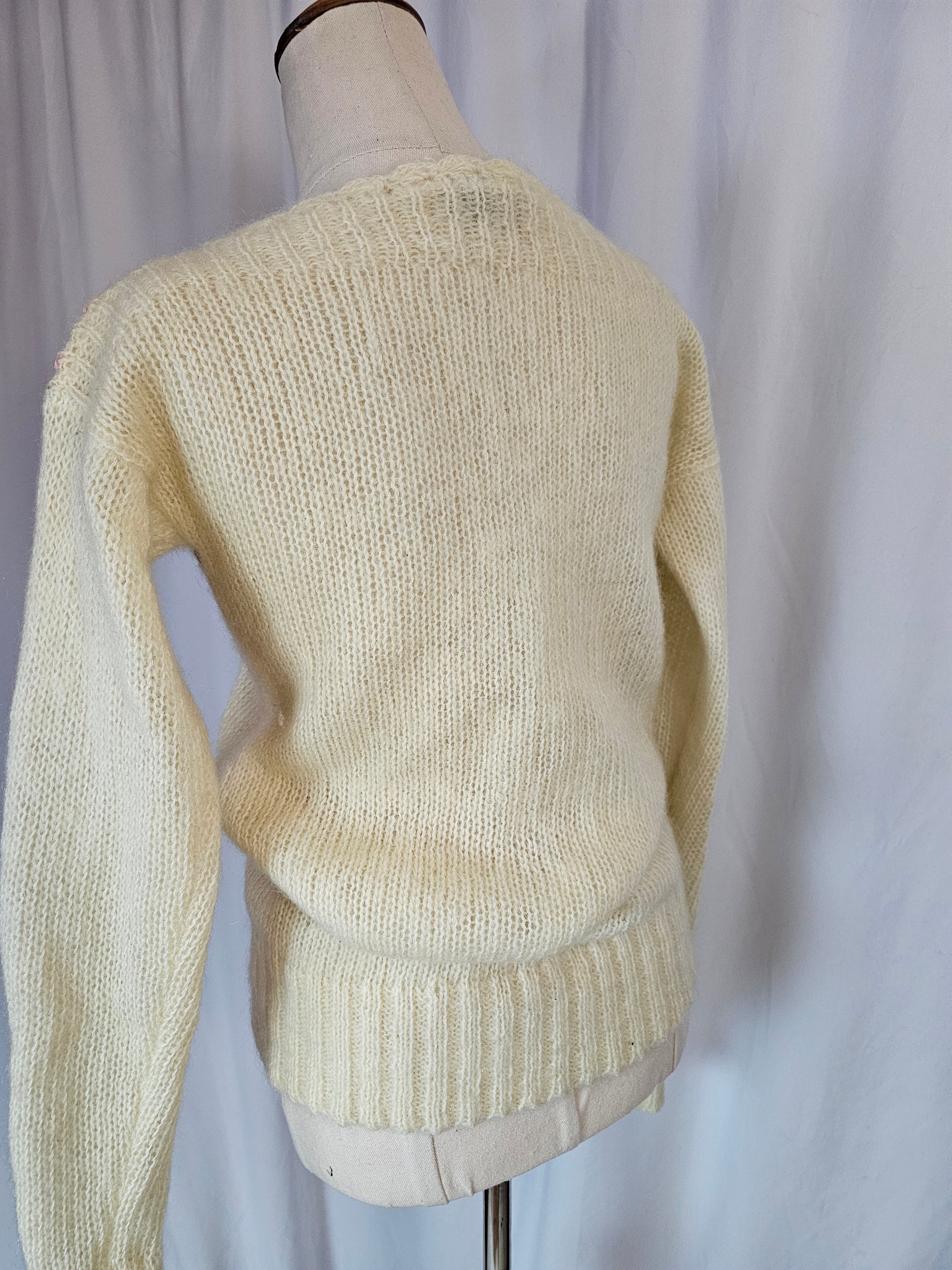 Beige sweater on a mannequin against a neutral background