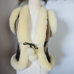 White shearling vest with fur trim on a mannequin against a neutral background