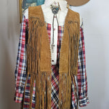 Mannequin wearing a brown fringe jacket over plaid shirt with a hat on a white background