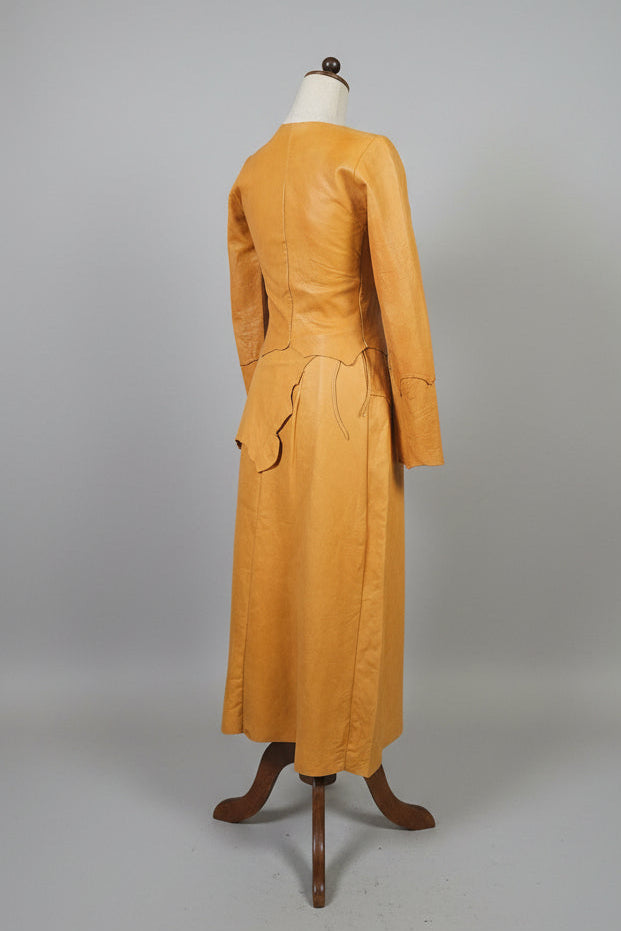 Tan leather jacket on a mannequin against a plain background