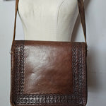 Brown leather handbag with studded detail on a mannequin against a white background