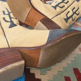 Pair of cowboy boots with wooden soles on a patterned rug