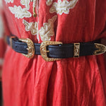 Decorative belt with gold buckle on a red fabric background