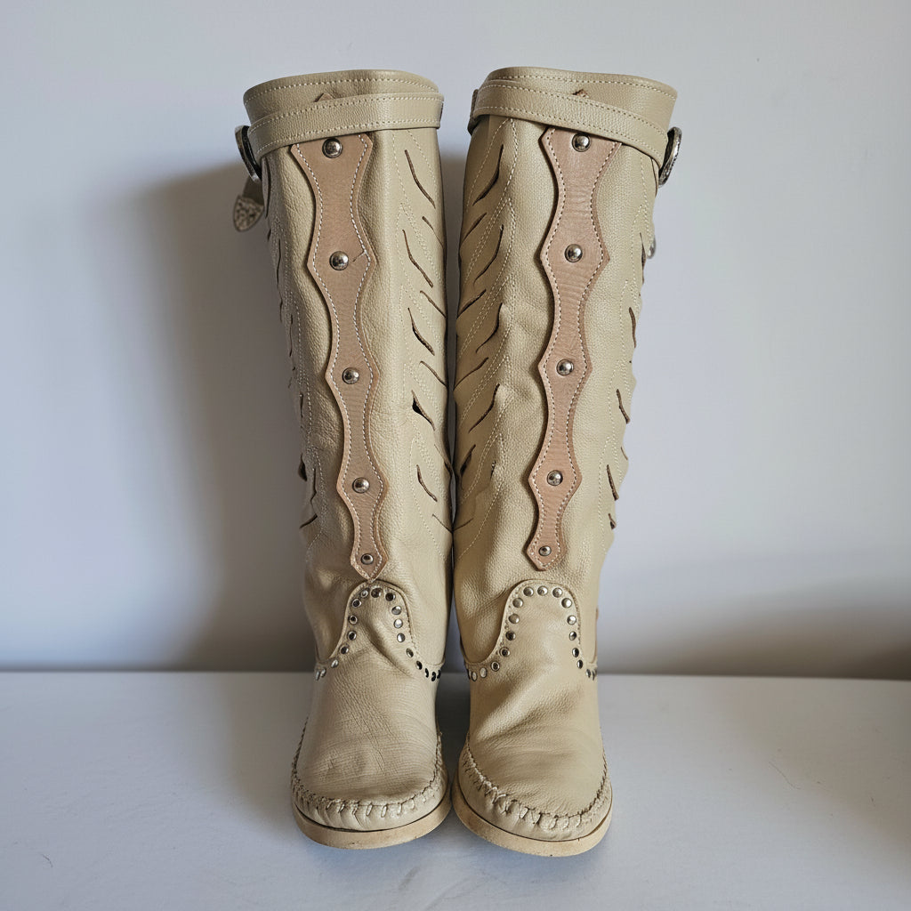 Pair of beige leather gloves with decorative stitching on a light background