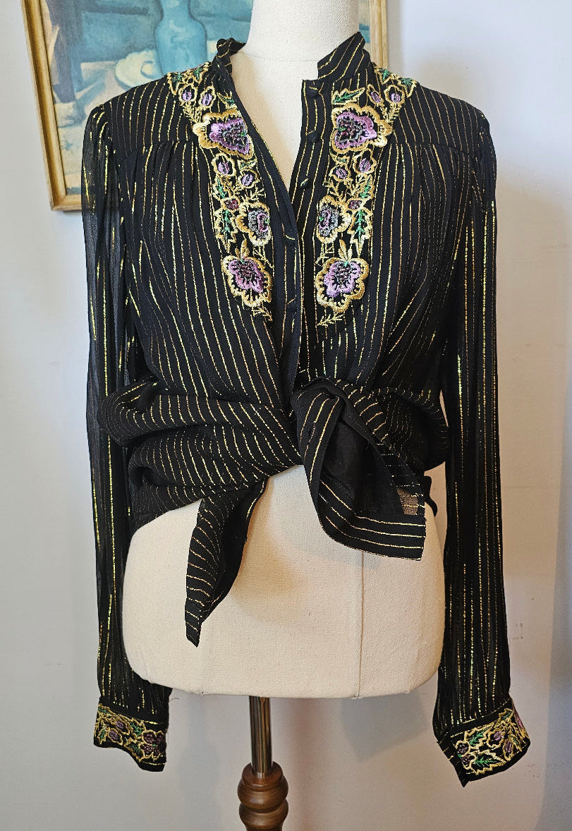 Black embroidered garment on a mannequin with a white background