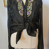 Black embroidered garment on a mannequin with a white background