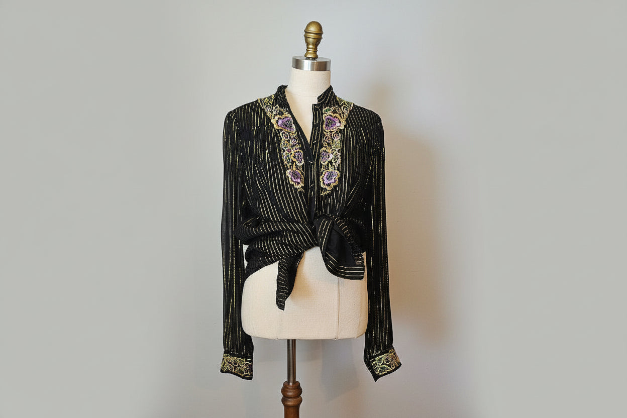 Black embroidered garment on a mannequin with a white background