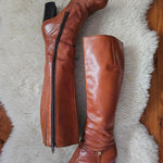 Brown knee-high boots on a fluffy white rug
