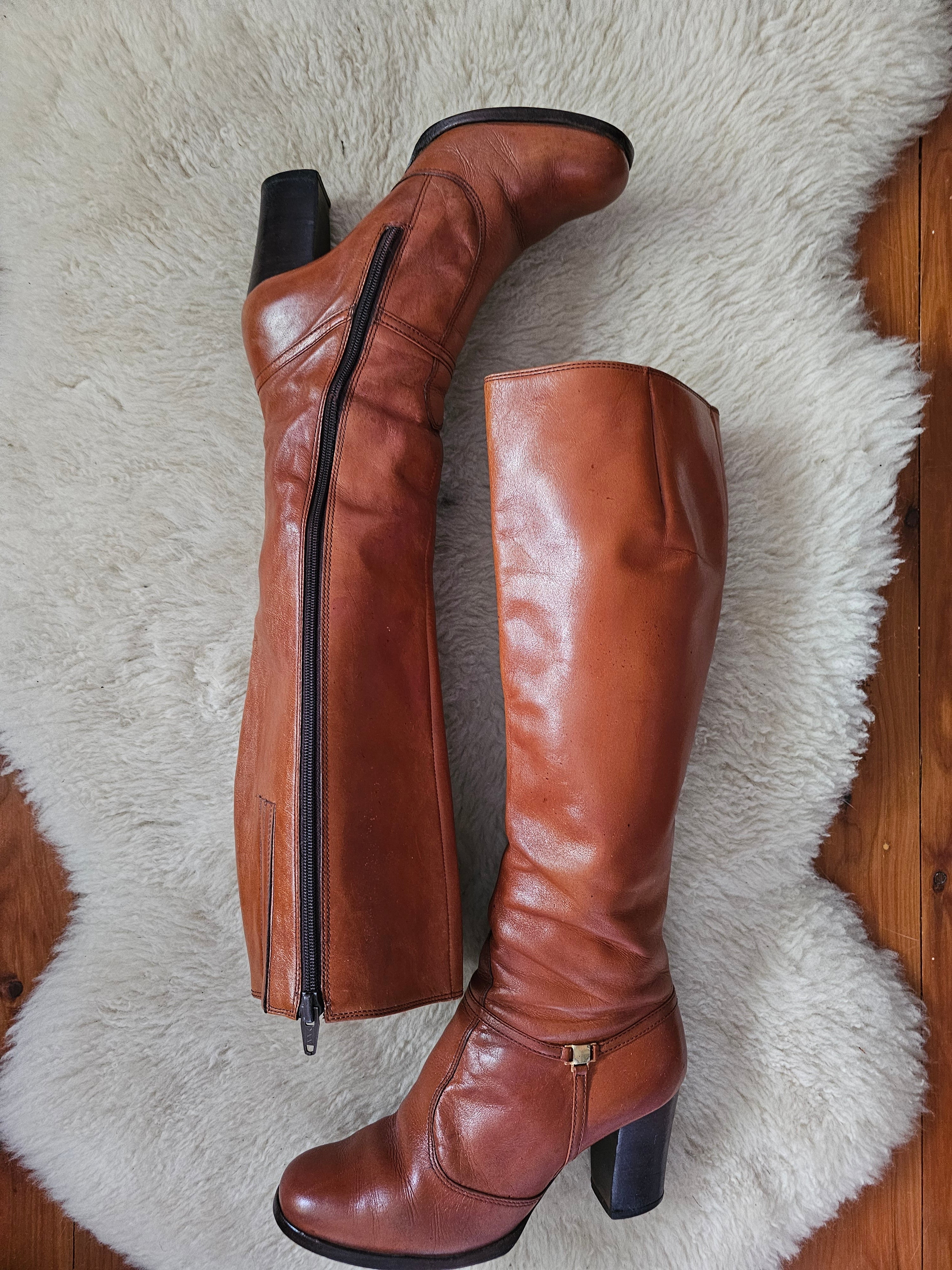Brown knee-high boots on a fluffy white rug
