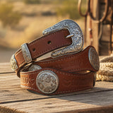 Brown leather belt with silver concho on a white background