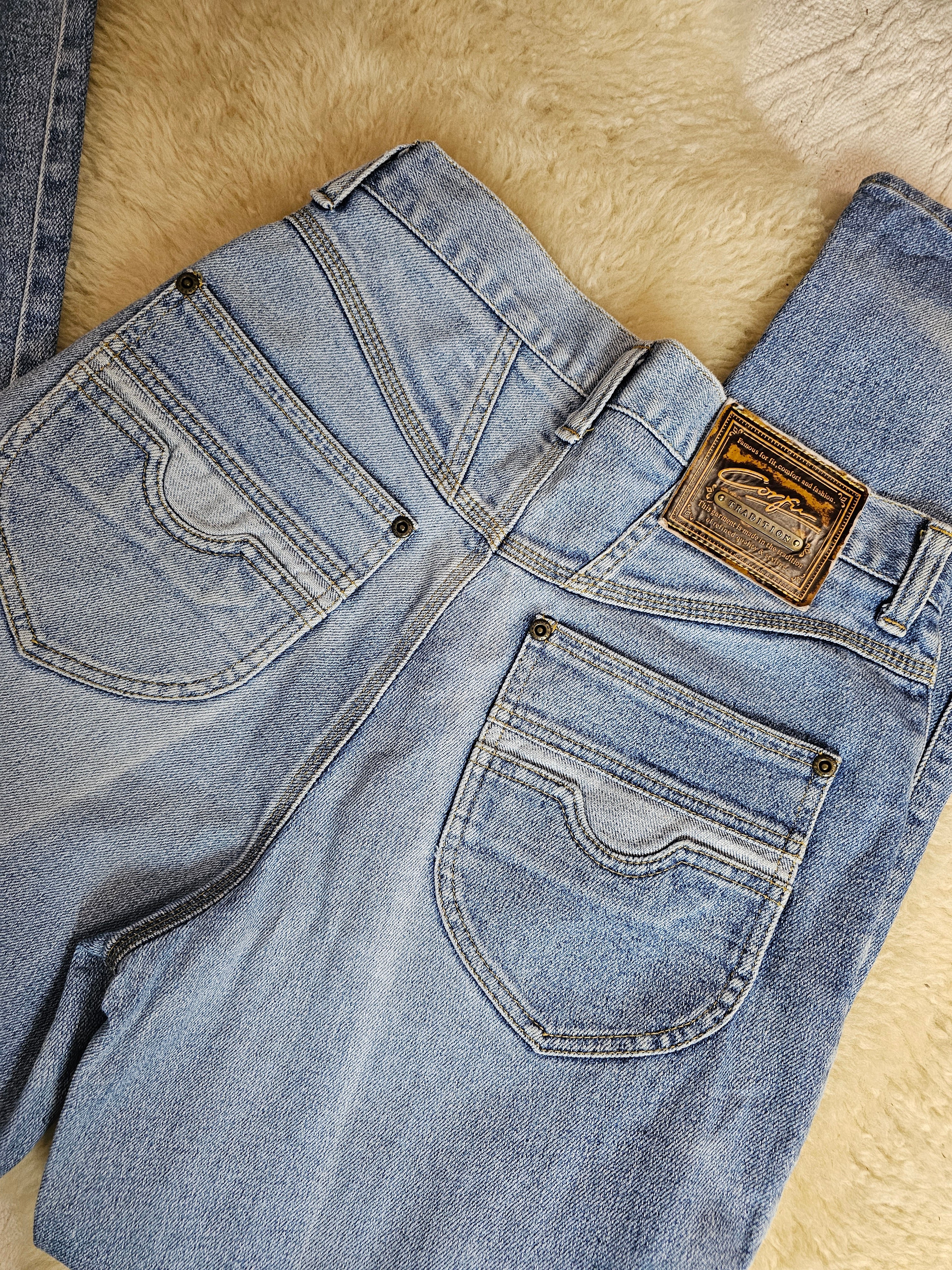 Pair of blue jeans with a brand logo on a wooden surface