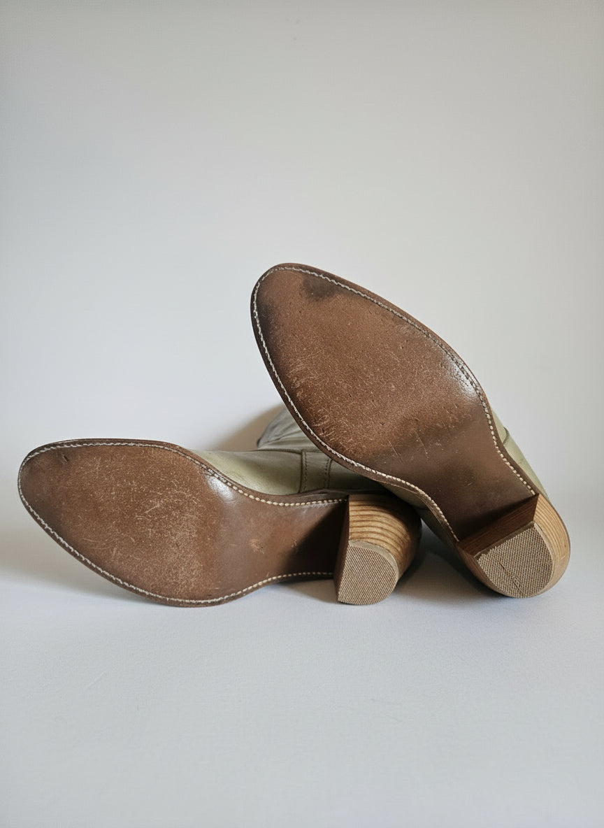 Brown leather shoes with wooden soles on a white surface
