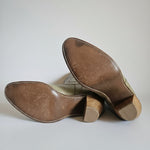 Brown leather shoes with wooden soles on a white surface