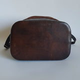 Brown leather saddle pad on a textured surface