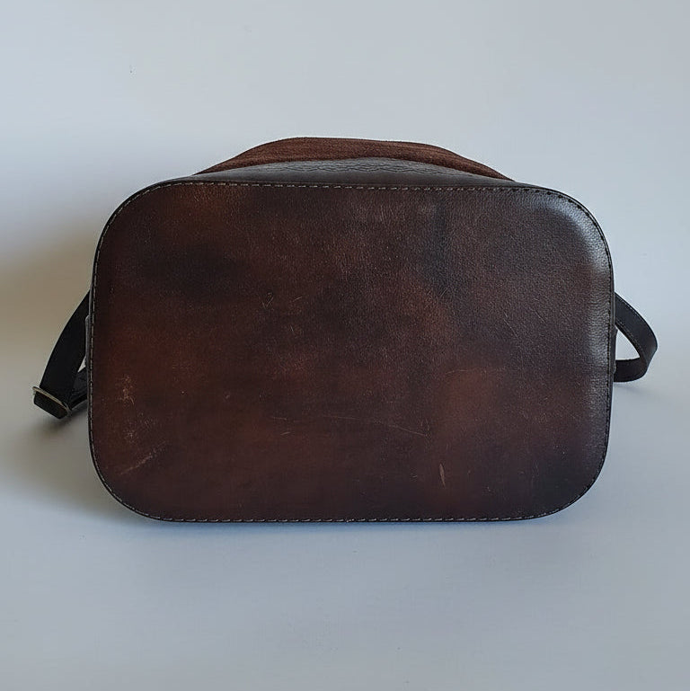 Brown leather saddle pad on a textured surface
