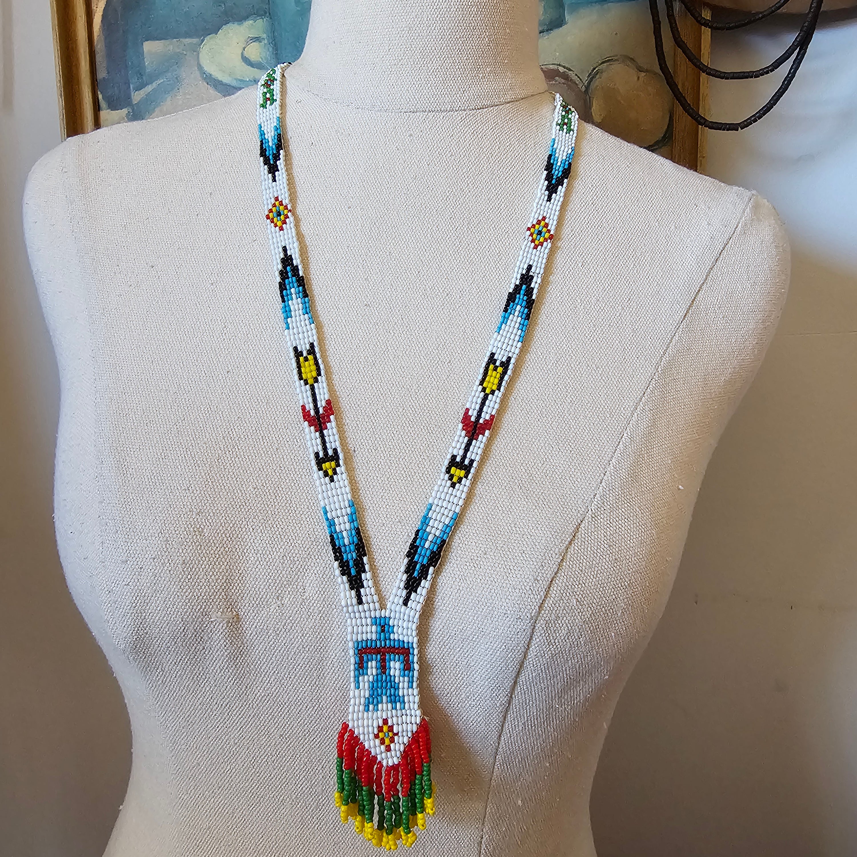 Mannequin head with a colorful beaded headband on a neutral background